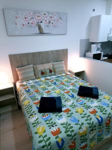 马拉加Apartamentos ZANCA CITY CENTER的床上有一条毯子,上面有鸟儿和鲜花