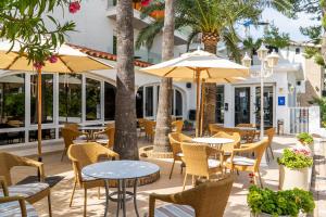 贝尼卡西姆贝索卡酒店的一个带桌椅的户外庭院,棕榈树