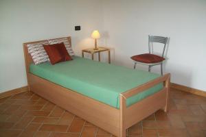 贝韦里诺La Casa Del Borgo的一间卧室配有一张带椅子和一盏灯的床