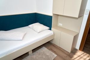 玛丽亚韦尔特Appartements am See的小房间设有床和蓝色的墙壁