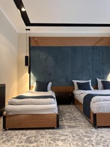 布哈拉Hotel Bukhara的一间卧室设有两张床和蓝色的墙壁