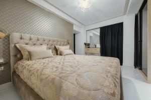 罗德镇Odysseus Luxury House的一间卧室配有一张大床和金色床罩