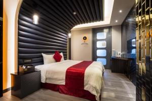 金山区金汤溫泉飯店的一间卧室设有一张大床和黑色墙壁