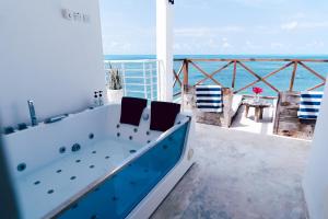 江比阿Pili Pili Tropical Island的浴缸位于海景阳台上方