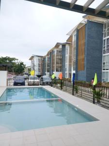 MaribagoFully Furnished Staycation - Neflix, Pool,Can cook near Mactan Airport的一座公寓大楼内的游泳池,大楼内有一座建筑