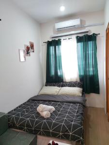 MaribagoFully Furnished Staycation - Neflix, Pool,Can cook near Mactan Airport的绿窗帘的房间的一张床位