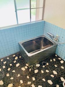 真庭市Yubara Hot Springs - Beautiful Riverside Hideaway的浴室内的一个金属水槽,铺有瓷砖地板