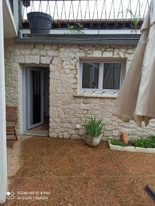 Saint-Front-la-RivièreLe Petit Cosy的石头房子,设有庭院和遮阳伞