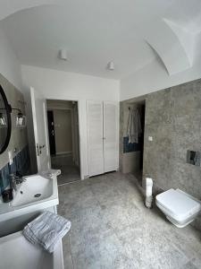 乌斯特卡Apartament Monopoli的白色的浴室设有水槽和卫生间。