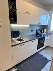 乌马格Apartment Eda - feels like home的厨房配有白色橱柜和水槽