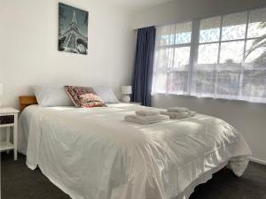 奥克兰Ali Motel的卧室配有白色床和毛巾