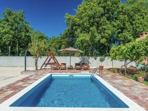 Donji ZemunikCharming holiday home with private pool的一个带椅子和遮阳伞的游泳池
