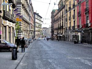 那不勒斯Maison Dante的一条空荡荡荡的城市街道,人们沿着街道走