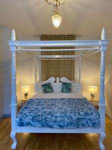 HolstedBoutique Hotel Postgården的一间卧室配有一张蓝色的床和白色的天篷