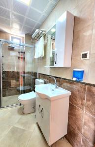安塔利亚Asimado Hotel的浴室配有卫生间、盥洗盆和淋浴。