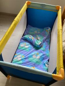 吉弗Hyrdeskolen的房间里的一张带毯子的蓝色婴儿床