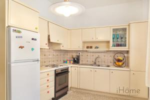 毕达哥利翁I Love Samos - Maisonette at the heart of Pythagorio的厨房配有白色橱柜和白色冰箱。