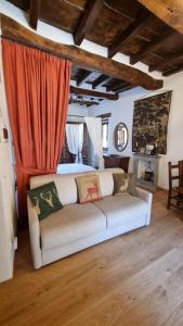 塞尼奥河畔帕拉佐洛La Torre del Vicario的带沙发和红色窗帘的客厅