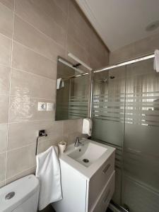 莱昂巴卡丽诺酒店的一间带水槽、卫生间和镜子的浴室