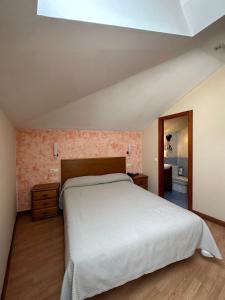 莱昂巴卡丽诺酒店的一间带白色大床的卧室和一间浴室