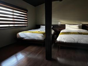 犬山市游月庵的卧室设有两张床,配有窗户和木地板