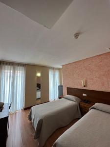 莱昂巴卡丽诺酒店的酒店客房设有两张床和电视。