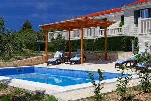 波尔Holiday Homes Oliva的一座带木凉亭的游泳池位于一座房子旁边