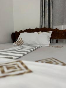 Stone TownSerene Abodes的一张带白色床单和枕头的床以及窗户