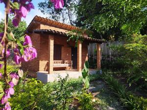 伦索伊斯Pousada Luar do Sertão的花园中带长凳的小砖屋