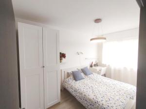 布达佩斯Forest Hill apartment的白色卧室配有蓝色枕头的床