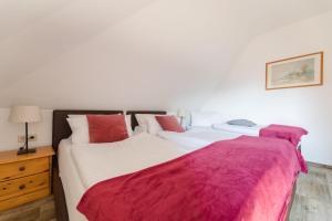 NiedersalweyLandhaus Salweytal的一间卧室配有两张红色和白色床单