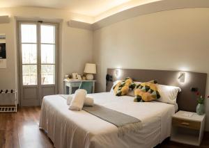 科尔托纳Locanda agli Amici的卧室设有一张白色大床和一扇窗户。