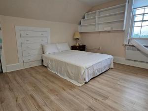 萨默赛德Sunflower Guest Suites的一间卧室配有一张床、一个梳妆台和一扇窗户。