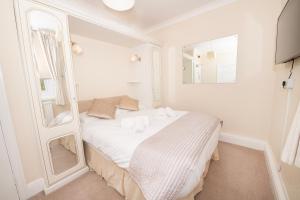 布里德灵顿The Seacourt的白色的客房配有一张带镜子的床