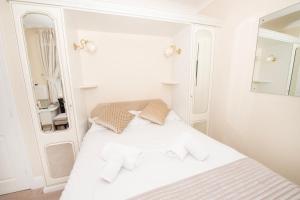 布里德灵顿The Seacourt的白色的客房内的一张白色床,配有镜子