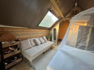 圣卢切Glamping Tuscany - Podere Cortesi的一间设有白色沙发和窗户的客房