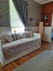 哈普萨卢Vintage Four的卧室配有带枕头的床铺和窗户。