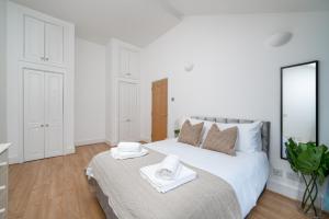 伦敦Modern 1 Bedroom City Penthouse Apartment的白色卧室配有一张大床和毛巾