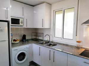 萨洛AGUILA DORADA的白色的厨房配有水槽和洗碗机