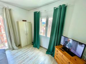 Ikia Village的客厅配有绿色窗帘和平面电视