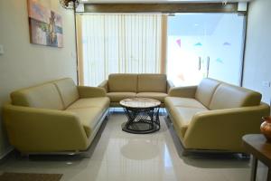 艾哈迈达巴德Hotel Royal Ican Sindhu Bhavan Road的一间设有两张真皮沙发和一张桌子的等候室