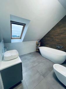 华沙Dream House SmartHome的一间带两个盥洗盆、浴缸和窗户的浴室