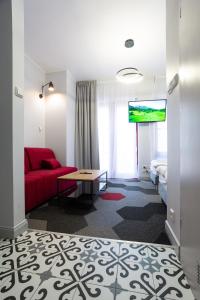 格但斯克Moon Apartments Gdańsk的酒店客房配有红色的沙发和床。