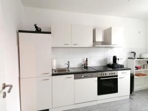 赫恩Wohnung in Herne Zentral mit Küche, Netflix, Disney Plus, DAZN的白色的厨房配有白色橱柜和水槽