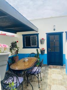 沃利迪耶Chez abdelilah的一个带桌椅的庭院和一扇蓝色的门