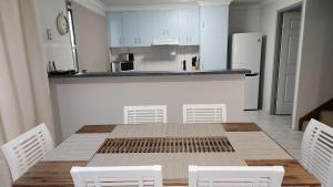 麦凯WhitsunStays - The Goose Ponds的厨房配有木桌和白色橱柜。