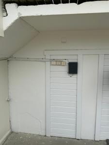 GratangenStorfossen Hostel的两扇白色车库门,上面有扬声器