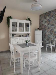 丽都玛里尼La casa di Stefy的厨房配有白色的桌椅和冰箱。