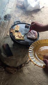 科伦巴Spot Jaguar Pantanal South Lodgen的一个人在烧烤架上烹饪食物