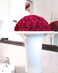米拉伊斯奥拉迪卡浦拉酒店的浴室里充满红玫瑰的白色花瓶